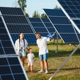 Happy family near solar panels. Alternative energy source.